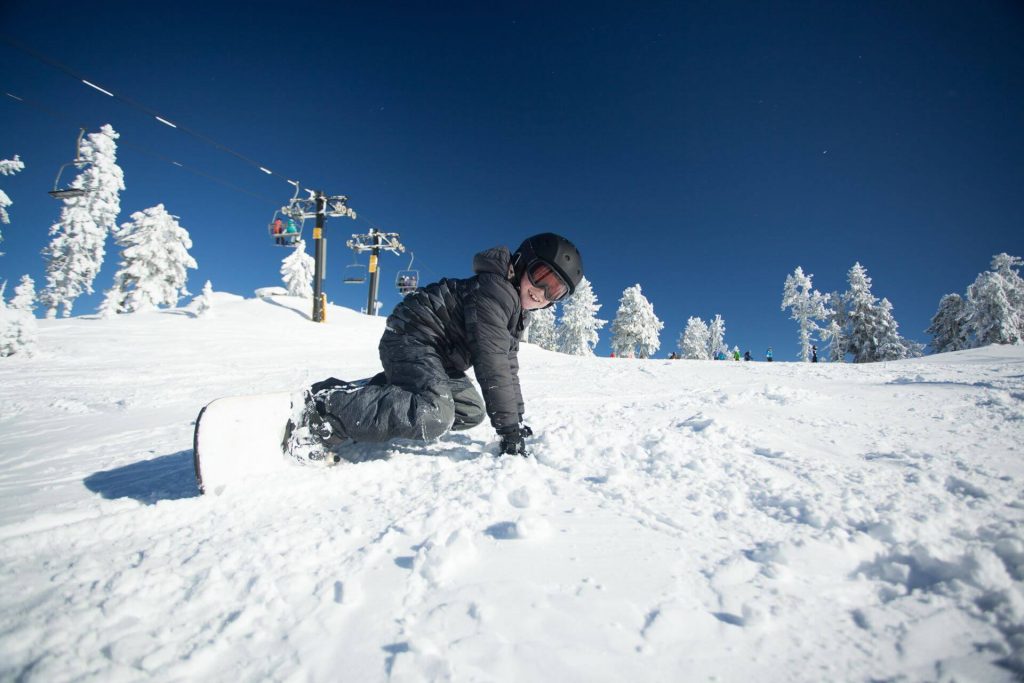 Mit dem Snowboard hinfallen und wieder aufstehen muss gut geübt sein.